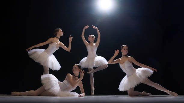 istock Four young girls, ballet dancers performing dramatic and elegant dance under spotlight, showcasing beauty of classical dance and artistry 2190686374
