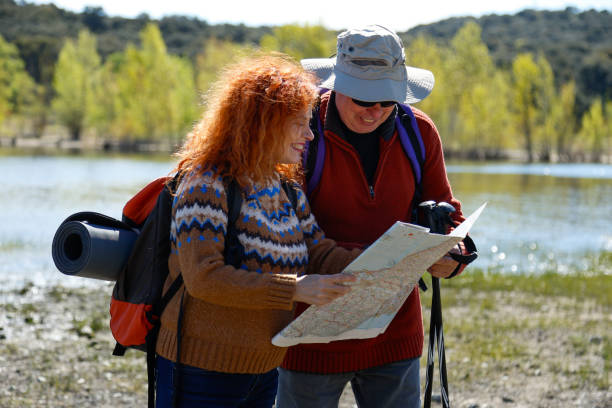 istock Hikers consulting map near lake during trekking excursion 2190690191