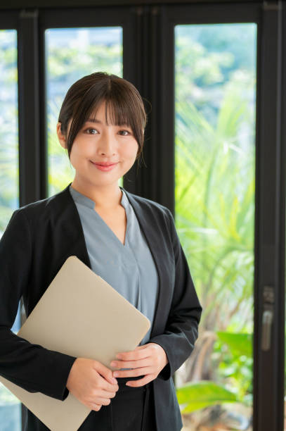istock A Japanese woman smiling with a computer 2190691481