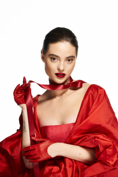 istock Elegant fashion model showcasing bold red attire in a stylish studio setup 2190694093