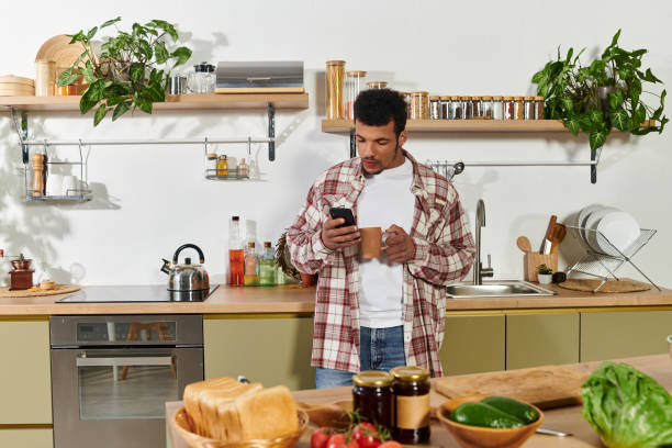 istock Young man enjoying a quiet moment while checking his phone in a stylish kitchen 2190694715