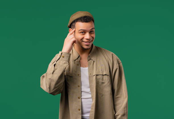 Stylish smart man with gesture - you, think about it. Looking camera on green