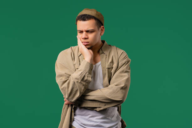 istock Young man with tooth pain, green background. Toothache, dental problem 2190696810