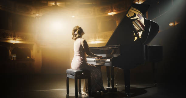 istock Female Pianist Playing Academic Music, Performing Classical Solo Compositions on Stage. Grand Piano Resounds With Rich, Melodic Tones of a Romantic Ballad, Asian Pianist Leaving the Audience in Awe 2190696839