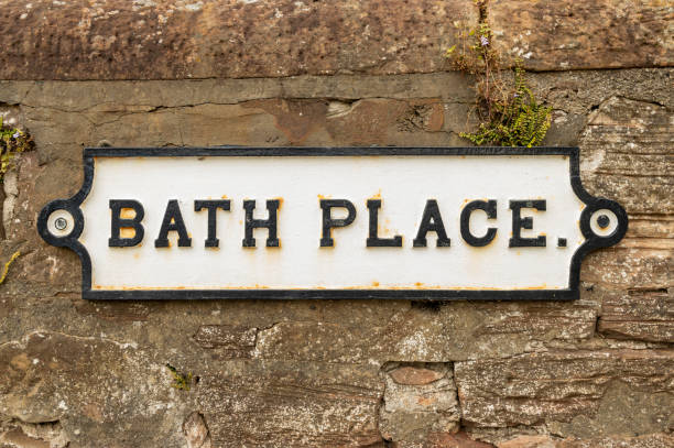 istock Cast iron white Bath Place street road sign with black text on sand stone wall 2190697370