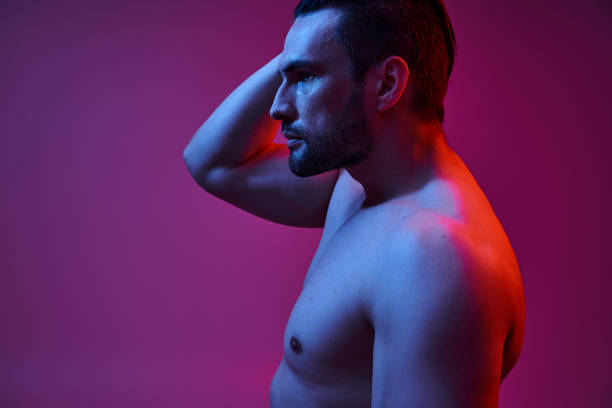istock Stylish young man poses confidently against vibrant red and blue background 2190699593