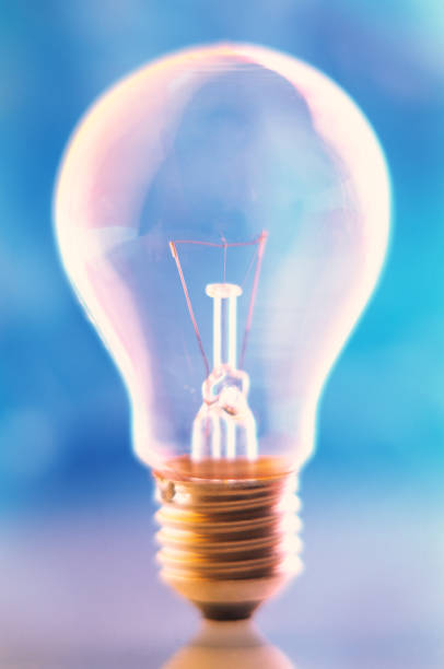 istock Incandescent lamp on a blurred blue background. 2190700099