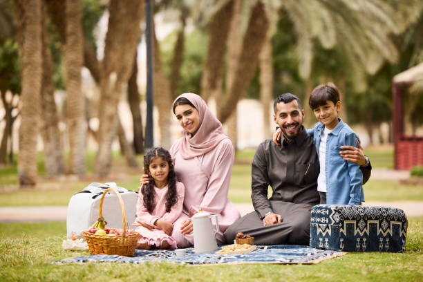 istock Happy middle eastern couple with kids at park 2190700667