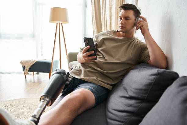 istock Handsome young man relaxing on sofa while enjoying music with prosthetic leg visible 2190703622