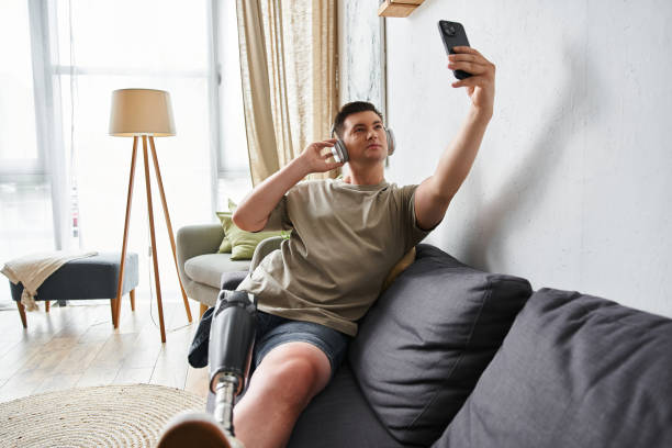 Young man with prosthetic leg captures a moment of joy while relaxing indoors