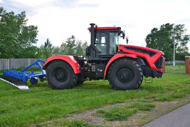 istock a red tractor with a black wheel with a plow on the side 2190703811