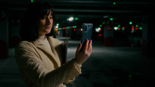 istock Young serious worker entrepreneur woman talk has phone virtual distant conference talking to phone web camera at parking lot. Businesswoman female speaking smartphone video chat call holding laptop 2190705872