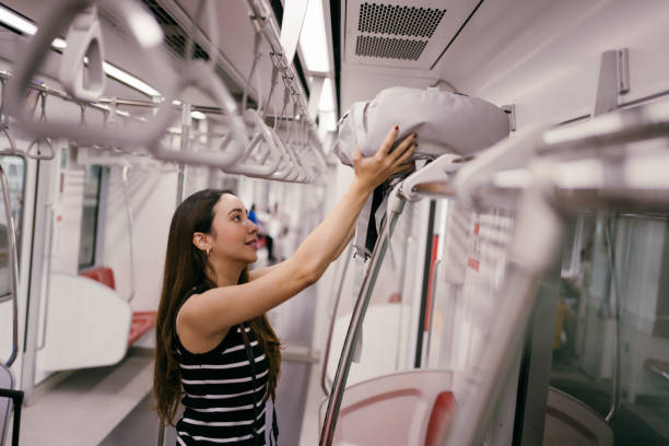 istock Young asian woman placing her backpack on the overhead rack while traveling on a modern subway train, enjoying a relaxed and comfortable commute through the city 2190706083