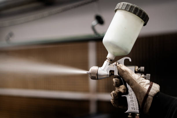 istock hands of a man with a paint gun expelling white paint 2190706217