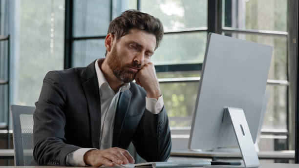 istock Sleeping tired lazy napping yawn adult bearded man male manager worker bored at work project online in computer in office Caucasian mature ill businessman need energy asleep feel overworked exhaustion 2190708490