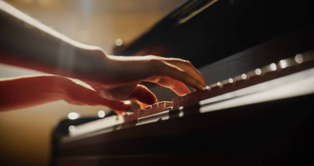 istock Close Up on Hands of a Talented Anonymous Pianist Making a Masterful Performance on a Grand Piano. Under Soft Stage Lights, Female Fingers Move Across the Keys, Creating Beautiful Classical Music 2190709969
