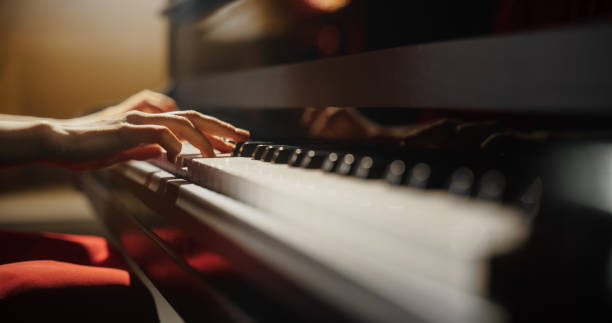 istock Close Up on Hands of a Talented Anonymous Pianist Making a Masterful Performance on a Grand Piano. Under Soft Stage Lights, Female Fingers Move Across the Keys, Creating Beautiful Classical Music 2190710002