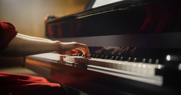 istock Close Up on Hands of a Talented Anonymous Pianist Making a Masterful Performance on a Grand Piano. Under Soft Stage Lights, Her Fingers Move Across the Keys, Creating Beautiful Classical Music 2190710022