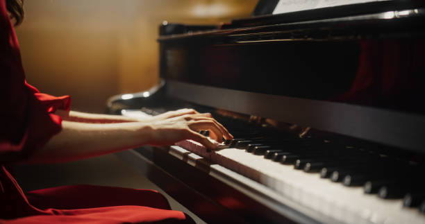 istock Close Up on Hands of a Talented Anonymous Pianist Making a Masterful Performance on a Grand Piano. Under Soft Stage Lights, Female Fingers Move Across the Keys, Creating Beautiful Classical Music 2190710057