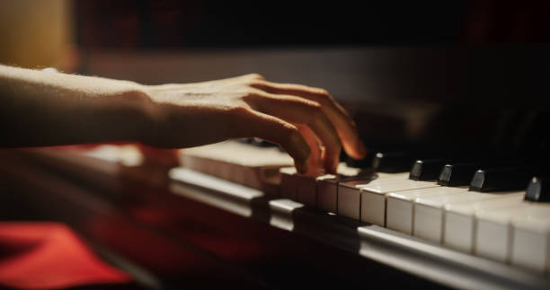istock Close Up on Hands of a Talented Anonymous Pianist Making a Masterful Performance on a Grand Piano. Under Soft Stage Lights, Female Fingers Move Across the Keys, Creating Beautiful Classical Music 2190710068