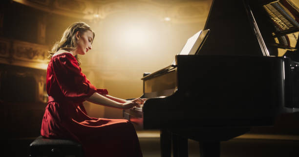 istock Female Pianist Playing Academic Music, Performing Classical Solo Compositions on Stage. Grand Piano Resounds With Rich, Melodic Tones of a Romantic Ballad, Young Pianist Leaving the Audience in Awe 2190710146