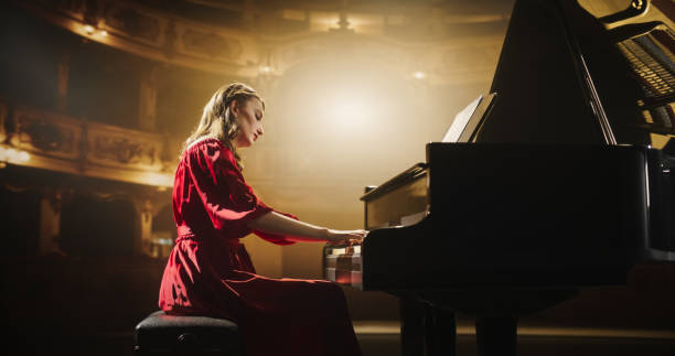 istock Female Pianist Playing Academic Music, Performing Classical Compositions on Grand Stage. Grand Piano Resounds With Rich, Melodic Tones of a Romantic Ballad, Young Pianist Leaving the Audience in Awe 2190710232