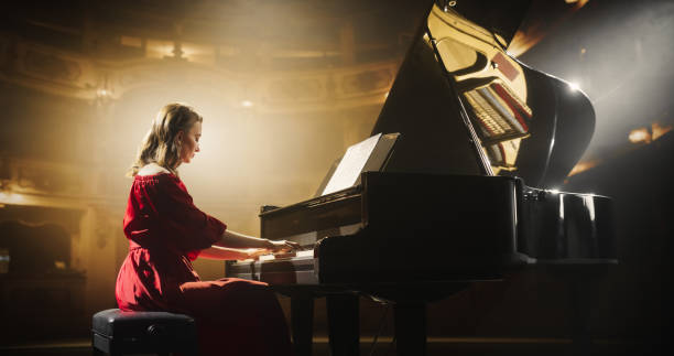 Female Pianist Playing Academic Music, Performing Classical Compositions on Stage. Grand Piano Resounds With Rich, Melodic Tones of a Romantic Ballad, Young Pianist Sitting with Her Back to Camera