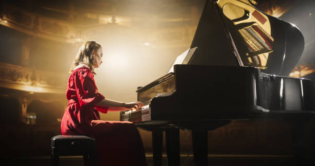 istock Female Pianist Playing Academic Music, Performing Classical Solo Compositions on Stage. Grand Piano Resounds With Rich, Melodic Tones of a Romantic Ballad, Young Pianist Leaving the Audience in Awe 2190710362