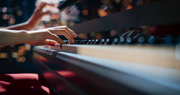 istock Close Up on Hands of a Talented Anonymous Pianist Making a Masterful Performance on a Grand Piano. Under Soft Stage Lights, Female Fingers Move Across the Keys, Creating Beautiful Classical Music 2190710445