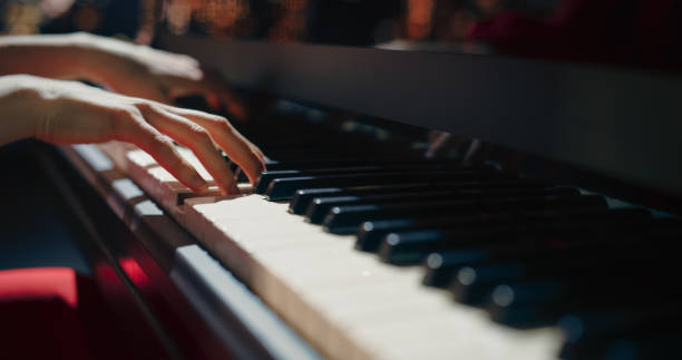 istock Close Up on Hands of a Talented Anonymous Pianist Making a Masterful Performance on a Grand Piano. Under Soft Stage Lights, Her Fingers Move Across the Keys, Creating Beautiful Classical Music 2190710477
