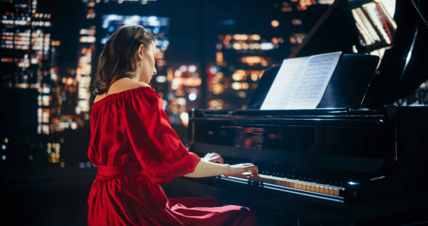 istock Female Pianist Playing Music From a Score Sheet, Performing Classical Compositions on Stage. Grand Piano Resounds With Rich, Melodic Tones. Portrait of a Classically Educated Pianist at a Concert 2190710552