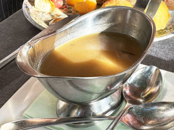 istock Delicious gravy in a silver sauce boat on a dining table, restaurant menu 2190711955