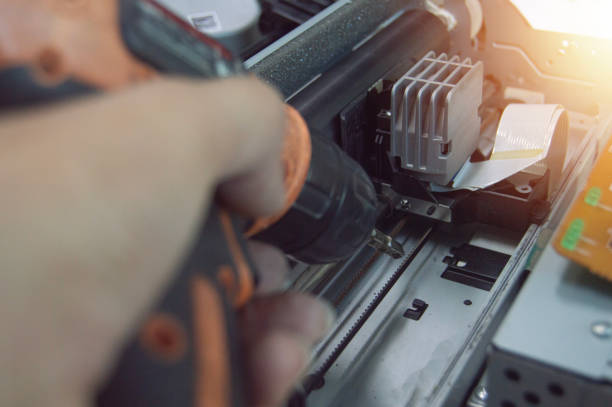 istock Side view of technician inspecting and repairing printer. 2190714385