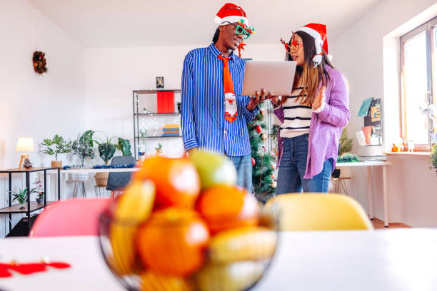 istock Colleagues celebrating new Year together in office while using laptop to keep up with work 2190715064