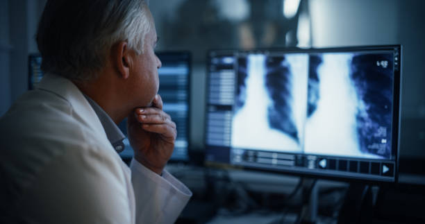 istock Male Doctor Inspecting X-ray Scans on an Advanced Diagnostic Software Technology in a Hospital in a Radiology Medical Office. Radiographer Working on a Computer, Looking at Medical Images 2190716561