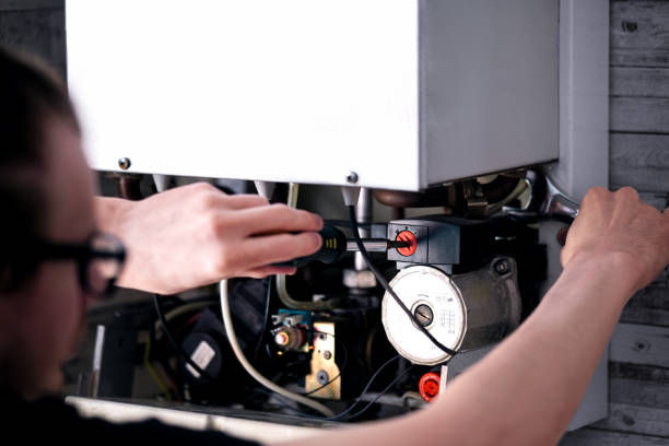 istock Man is repairing a heating boiler, a screwdriver and a spanner in his hands. 2190716748