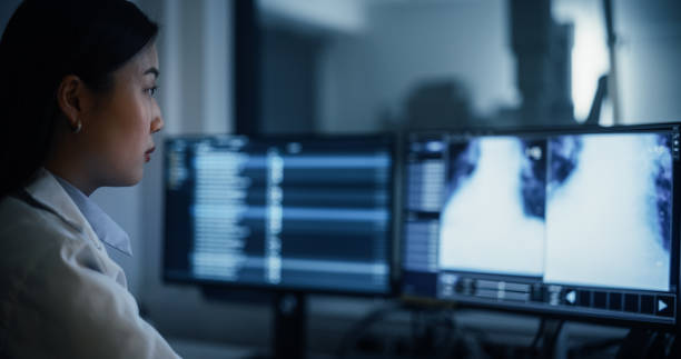 istock Asian Female Doctor Inspecting X-ray Scans on an Advanced Diagnostic Software Technology in a Hospital in a Radiology Medical Office. Radiographer Working on a Computer, Looking at Medical Images 2190716759