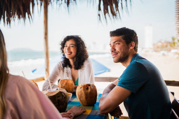 istock Young man talking to friends in restaurant on the beach 2190716887