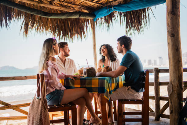 istock Friends talking in restaurant on the beach 2190716909