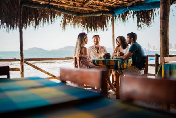 istock Friends talking in restaurant on the beach 2190716915