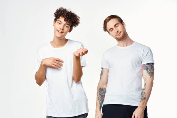 istock Two cheerful friends in white t-shirts emotions positive light background 2190717636
