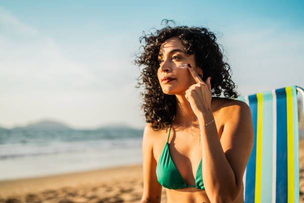 istock Young woman applying sunscreen on the beach 2190718501