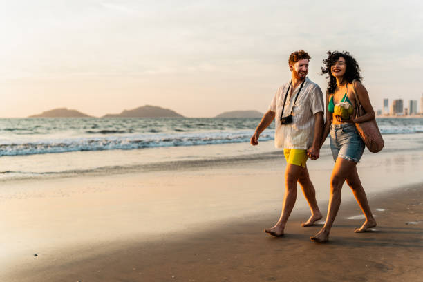 Young couple talking and walking on the beach