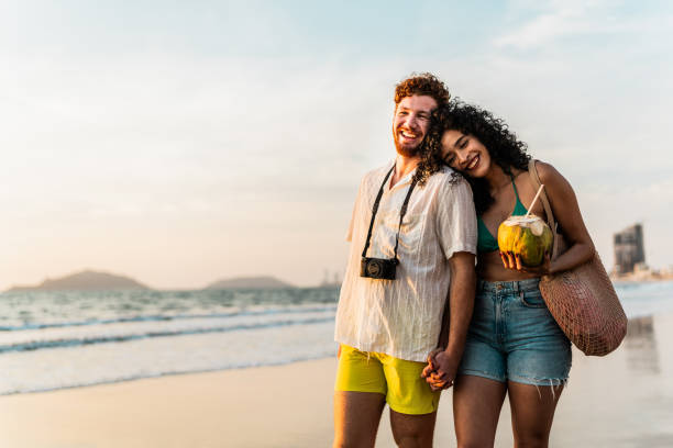 istock Young couple talking and walking on the beach 2190718673