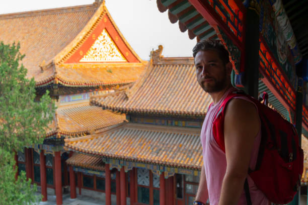 istock Young latin backpacker fit tourist male with a backpack looking directly at the camera while visiting Beijing, China, fully immersed in the experience of solo travel across Asia 2190719813