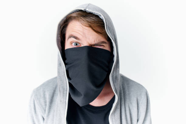 a man in a hood hides his face in a mask bully anonymity. High quality photo