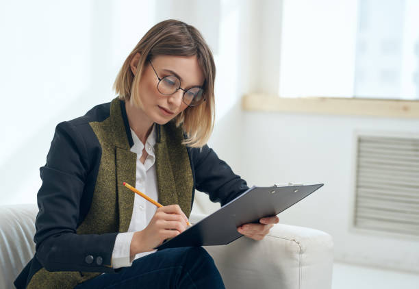 istock woman in a suit sitting in a chair documents 2190723831