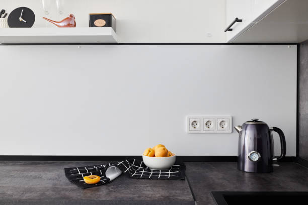 A Modern Minimalist Kitchen featuring Vibrant Citrus Fruits and a Sleek Electric Kettle