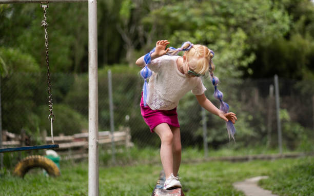 albino girl with long blonde hair playing in the park outdoors