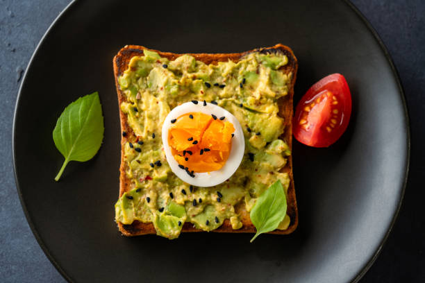 istock Healthy avocado toasts with eggs on black 2190726189